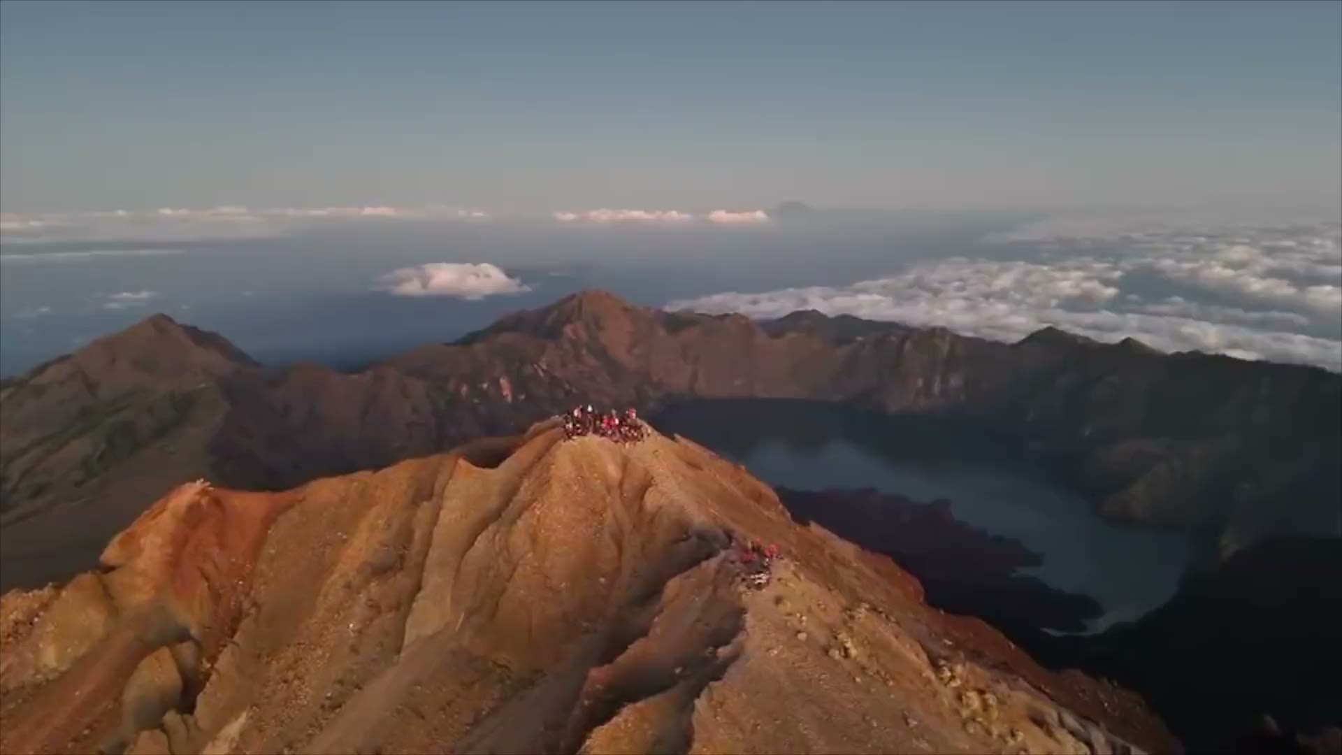 Mount Rinjani's crater rim above the clouds at sunrise